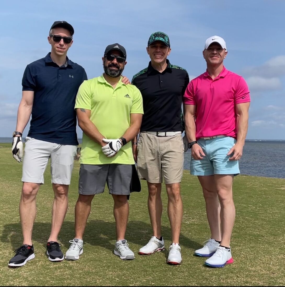 Four veterans posing together beside the bay