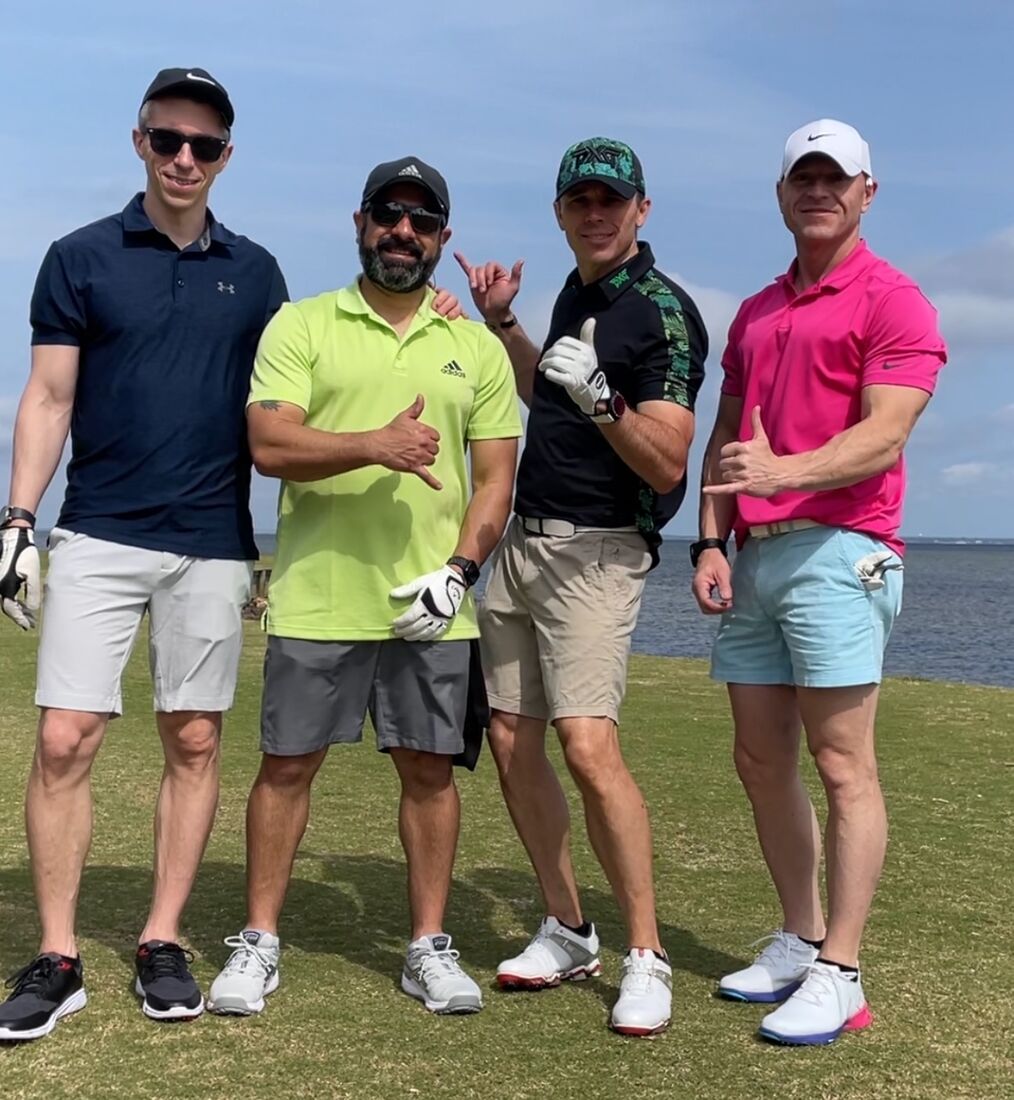 The same foursome throwing hang-loose signs beside the bay