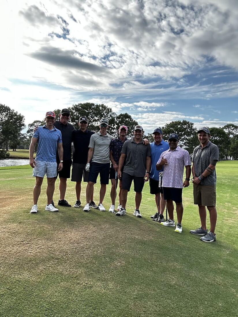 Nine veterans posing together on the tee