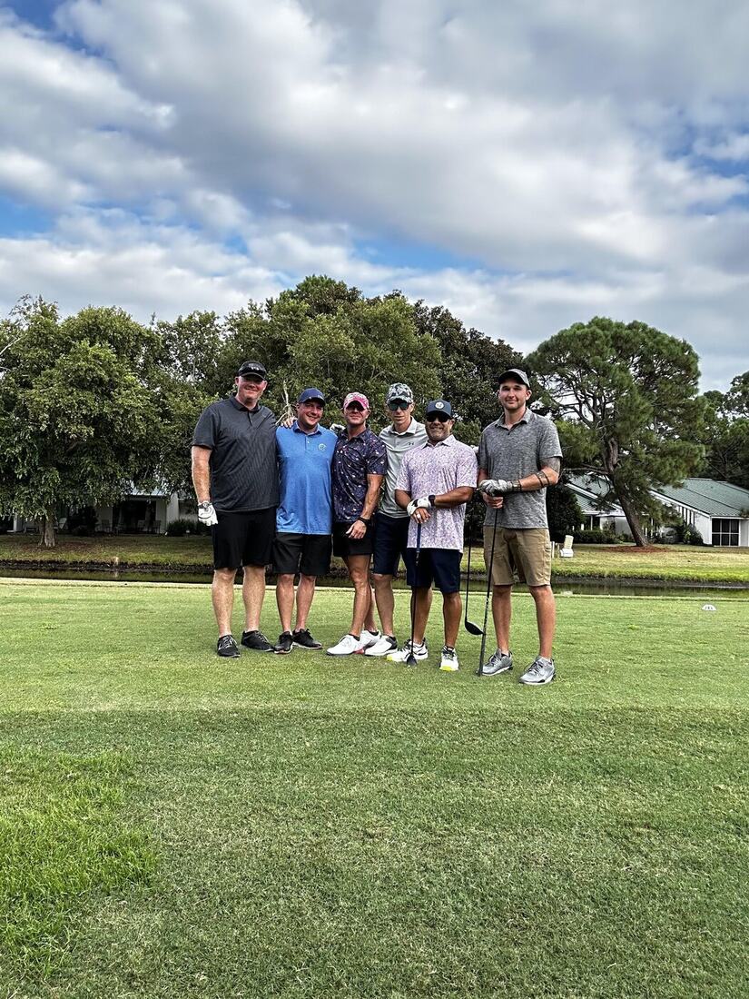 Six veterans posing together on the tee